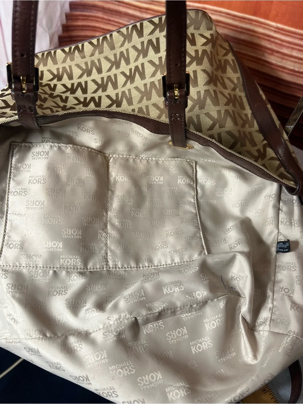 Michael Kors Jet Set tote features monogram canvas, contrasting leather straps